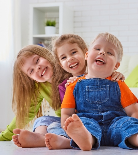 Three kids with healthy smiles after visiting their children's dentist in Addison New York