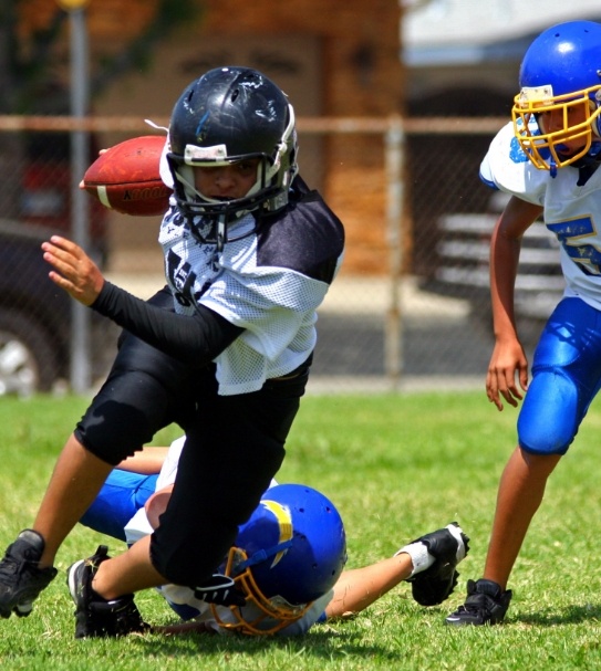 Children playing football with athletic mouthguards in place
