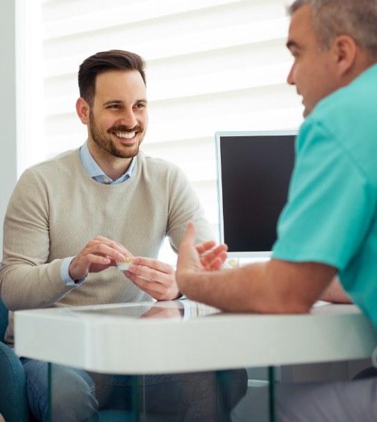 Dental patient discussing the cost of dental emergencies with dentist