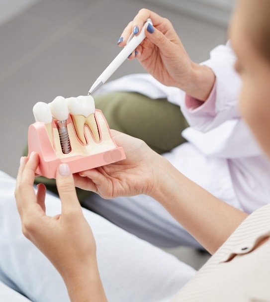 Dentist and dental patient discussing the four step dental implant process