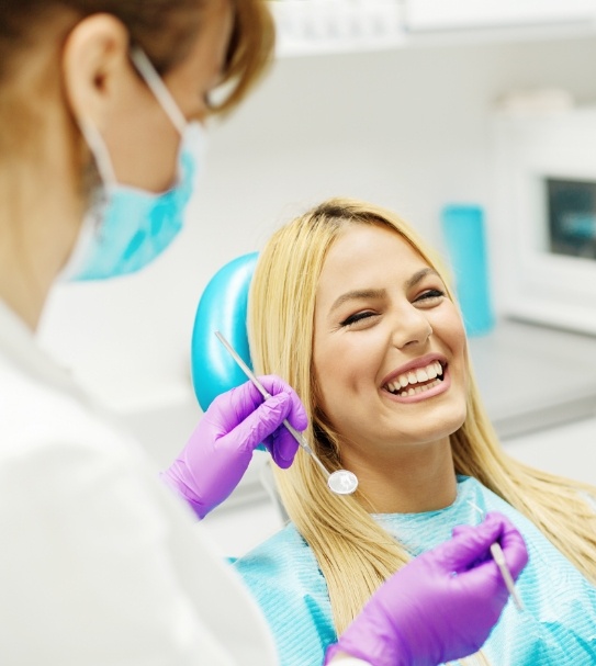 Woman laughing with dentist during dental treatment visit
